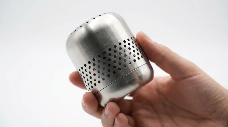 Hand holding FreshCore stainless steel device showing premium build quality